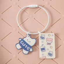 Detail of candy color keychain with cute cartoon bear charm and white woven lanyard strap