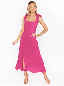 Detail of magenta dress showing bow-tie shoulder straps and ruffled side slit hem