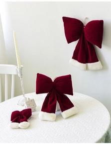 Detailed view of red velvet Christmas bows with white faux fur trim in festive setting
