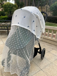 Detail of baby stroller sunshade cover with blue dolphin and floral patterns mesh