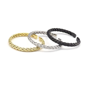Detailed close-up of woven stainless steel bangles in gold, silver, and black finishes