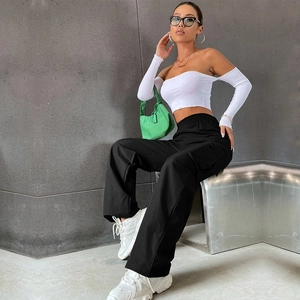 Look moderne avec haut en maille à épaules dénudées blanc et pantalon cargo noir à poches