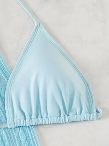 Détails d'un haut de bikini triangle bleu clair avec plis subtils et coutures précises