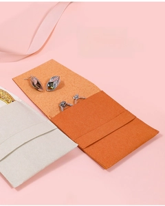 Macro detail of microfiber jewelry envelope organizer with ring slots in orange and beige