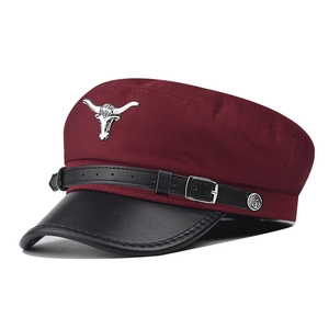 Vue détaillée d'une casquette militaire bordeaux avec emblème de taureau en argent