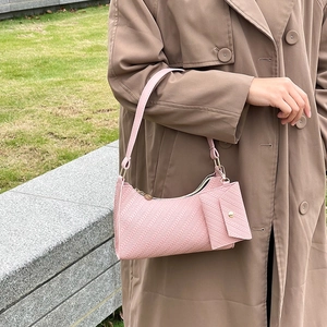 Chic pink textured two-piece underarm bag shown on model with matching mini pouch set