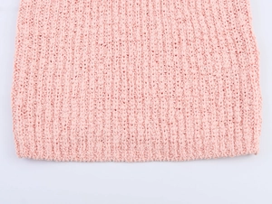 Macro shot showing soft pink knit texture and fine stitching detail on organza vest top