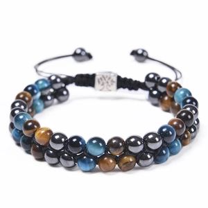 Detail of double-layer beaded bracelet with blue tiger eye and tree of life metal charm