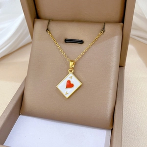 Close-up of heart Ace pendant in gold finish with white enamel and luxury crystals