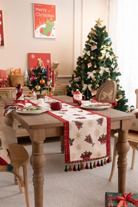 Close-up of jacquard Christmas table runner featuring red tassels and festive patterns