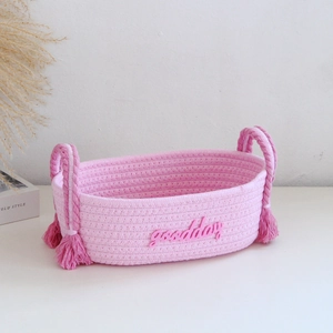 Pink cotton rope storage basket with goodday lettering and fringe handle detail
