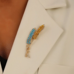 Exquisite wheat ear brooch with blue and yellow crystals on beige blazer lapel