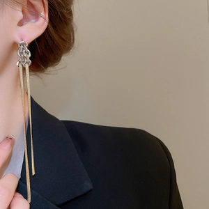 Gros plan de boucles d'oreilles pampilles longues avec finition métal bicolore or et argent