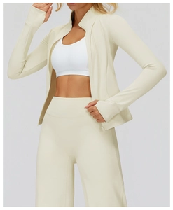 Close-up of cream-colored slim fit sports jacket and high-waisted yoga pants on model