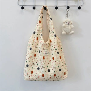 Detail of cream bubble fabric tote bag with bear pattern and soft plush sheep charm