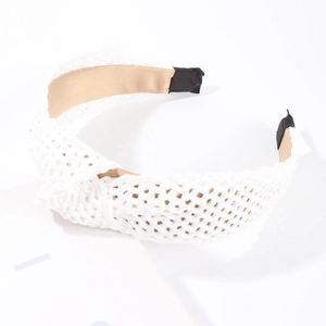 Détail d'un serre-tête en raphia tressé blanc avec nœud et doublure intérieure