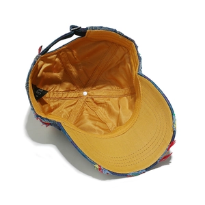 Dettaglio del cappellino in denim vintage con bordi sfrangiati colorati e fodera gialla