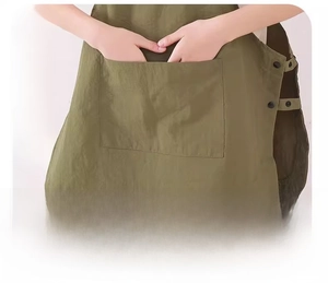 Detail of olive green apron featuring large multi-functional pockets and side buckles