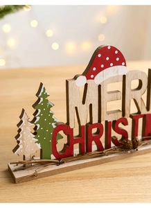 Close-up of a wooden Merry Christmas tabletop ornament with festive pine cone details