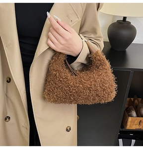 Gros plan d'un sac en peluche marron avec anse en cuir porté sur un trench-coat