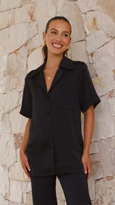 Detail of premium black satin pajama set showing the lapel collar and silky texture