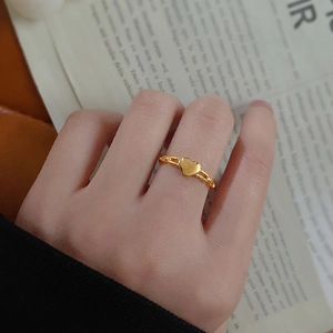Bague chaîne cœur dorée minimaliste pour femme portée sur la main, design élégant
