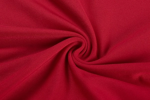Macro shot of dark red textured fabric with subtle silk-like luster and soft drape