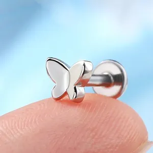 Polished F136 titanium butterfly stud earring held on fingertip for size comparison