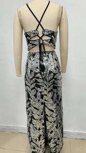 Détail du dos croisé d'une robe de soirée deux pièces noire à paillettes argentées