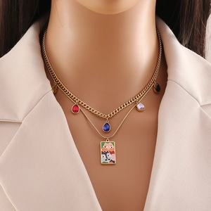 Detailed view of gold double-layer necklace with colorful teardrop gems and face art pendant