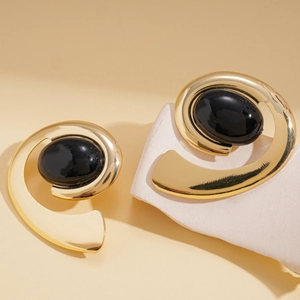 Retro geometric spiral earrings with black oval inlay on white stone pedestal