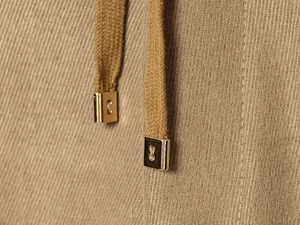 Close-up of ribbed knit fabric texture with premium gold metal drawstring tips