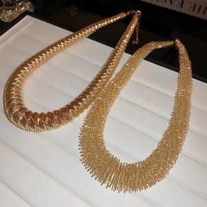 Macro detail of two different textures on gold braided metal necklaces for women