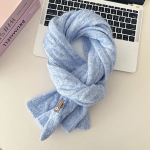 Detailed view of light blue cable knit wool scarf with premium leather brand tag