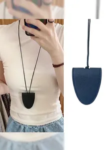 Close-up of black litchi grain leather pendant bag with sleek necklace neck strap