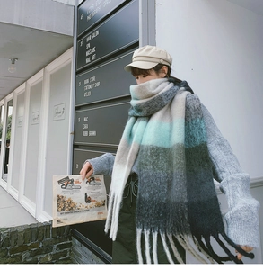 Detail of gradient oversized scarf with soft fringe and thick knit texture in winter