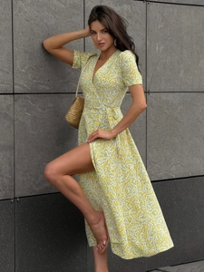 Detailed close-up of V-neck wrap dress with yellow floral pattern and side slit