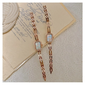 Detail of rose gold square watch with mother of pearl dial and sparkling diamond accents