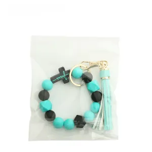 Detailed view of silicone bead keychain with Jesus cross pendant and leather tassel