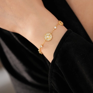 Detail of 18K gold-plated starburst bracelet with zircon crystals on woman's wrist