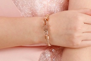 Bracelet en maille or rose avec pendentif Main de Fatma et détail de cœur évidé