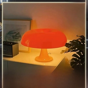Detail view of orange mushroom lamp with three-color dimming on a white bedside table