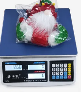 Detailed view of long-hat Christmas gnome doll being weighed on a scale for 126g accuracy