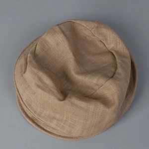 Detailed view of the natural linen texture and stitching of the beige newsboy cap