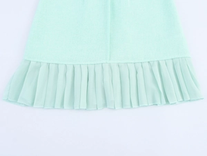 Detailed view of mint green tweed dress featuring a pleated chiffon ruffled hemline