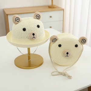 Détail d'un chapeau de paille pour enfants et sac assorti avec oreilles d'ours mignonnes
