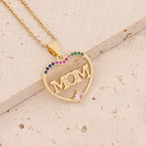 Macro detail of 18K gold heart necklace with MOM lettering and colorful zircon stones