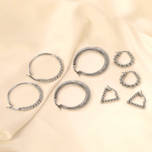 Minimalist silver stainless steel hoop earrings with beads on elegant satin background