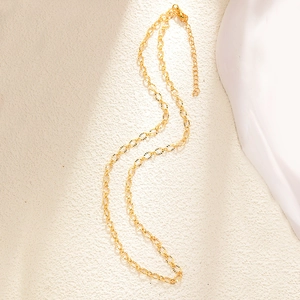 Detail of gold-plated chain link necklace with textured engraving and lobster clasp