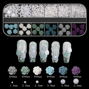 Macro shot of 12-grid nail art set featuring 3D aurora roses and gradient white pearls